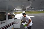 Teen loading supplies into airplane 