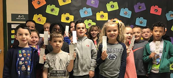 Students hold up reading cards