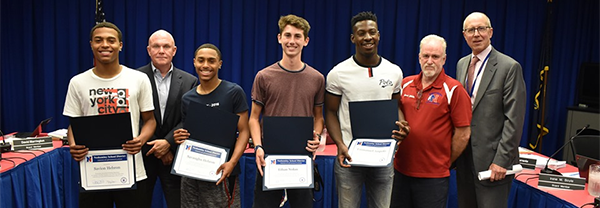 Neshaminy HS track team relay members hold up certificates at a Board meeting