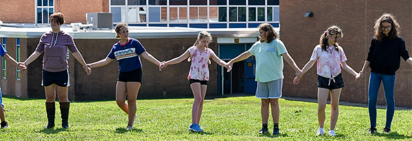 Students holding hands during a team-building exercise