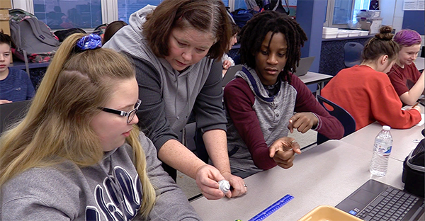 Poquessing students work on a science lab with their teacher.
