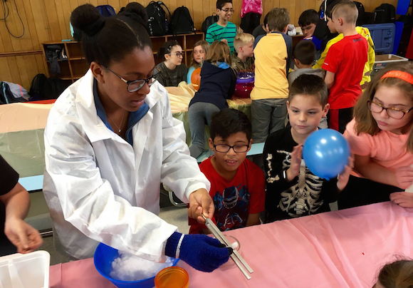 NHS Science Club member works with 5th grade students at Sandburg MS